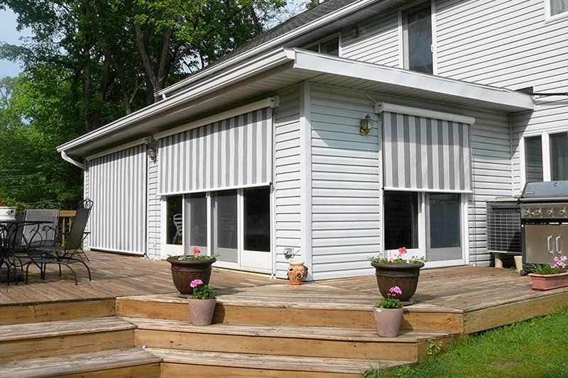 A white house with a striped awning on the side