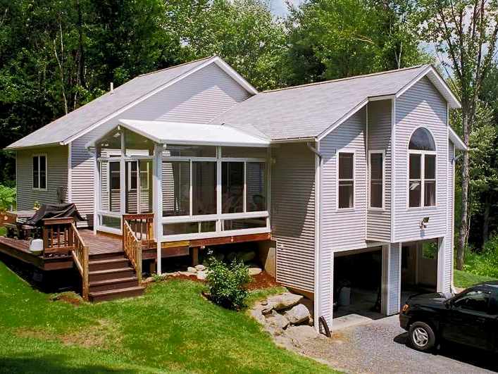 A white house with a car parked in front of it
