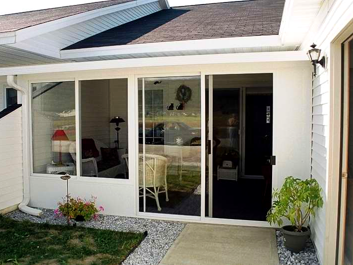 A white house with a sliding glass door that leads to a living room
