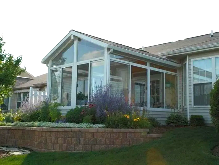 A house with a sunroom on the side of it.