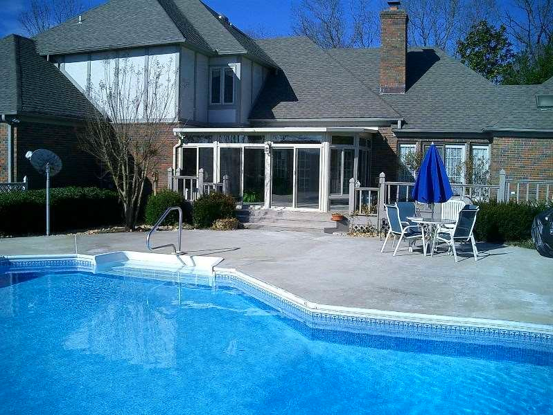 A large house with a swimming pool in front of it
