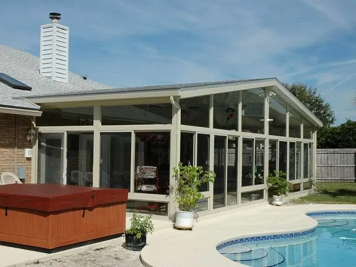 A house with a pool and a hot tub in front of it