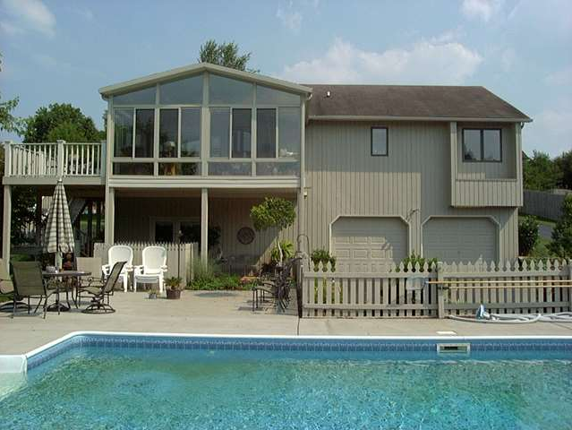 A large house with a swimming pool in front of it