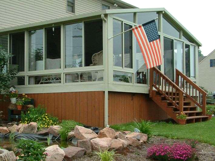 A screened in porch with stairs and an american flag