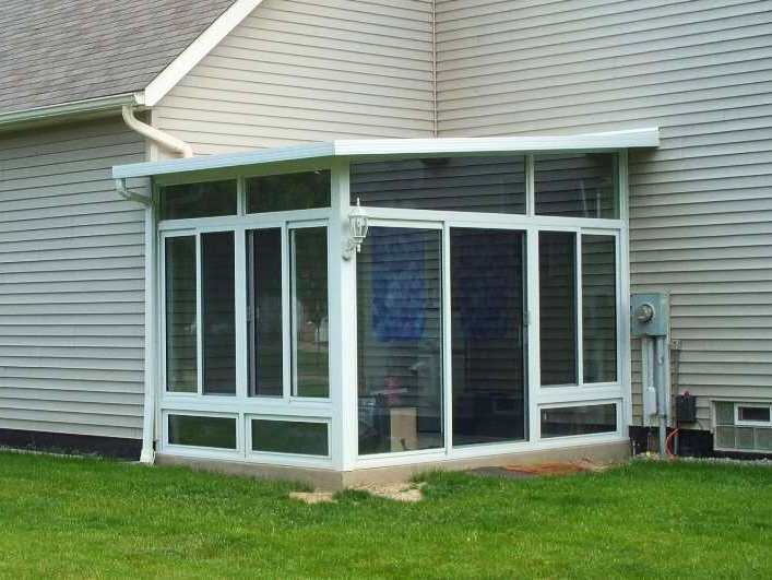 A screened in porch on the side of a house