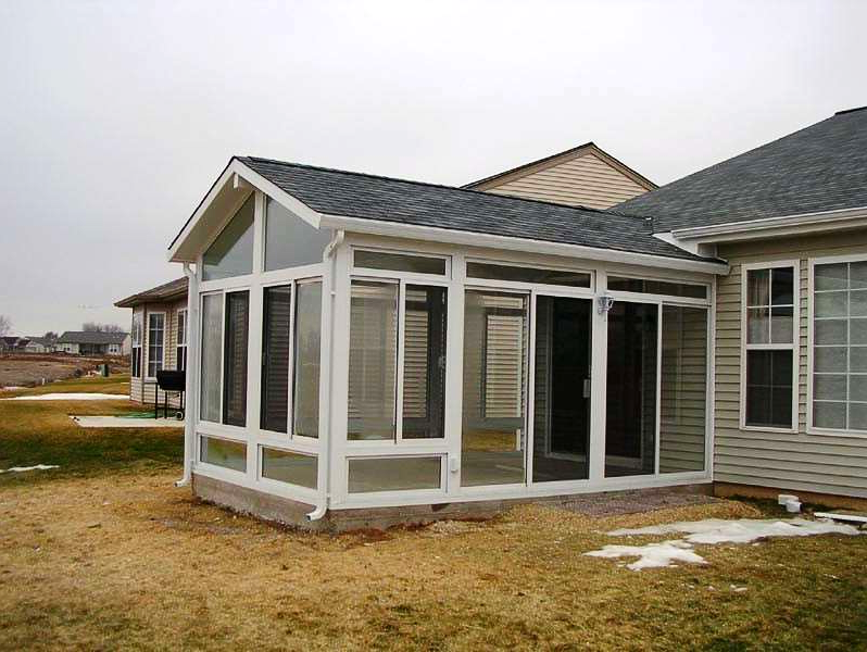 A house with a screened in porch and a roof