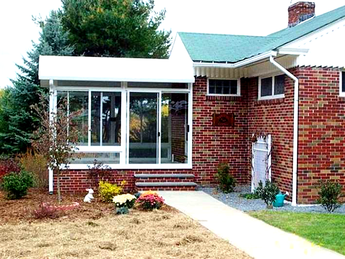 A brick house with a sunroom on the side of it