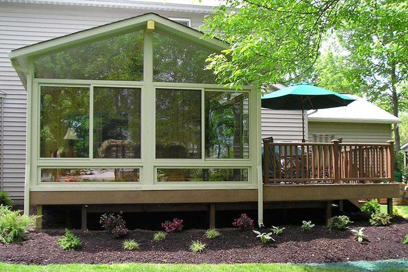 A house with a screened in porch and a deck