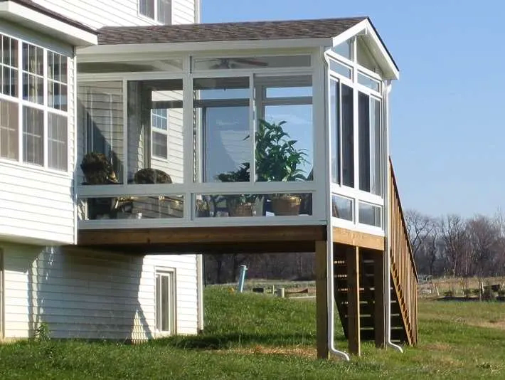A screened in porch on the side of a house