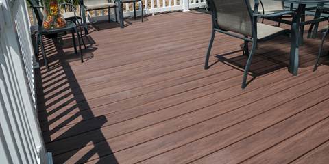 A wooden deck with a table and chairs on it.