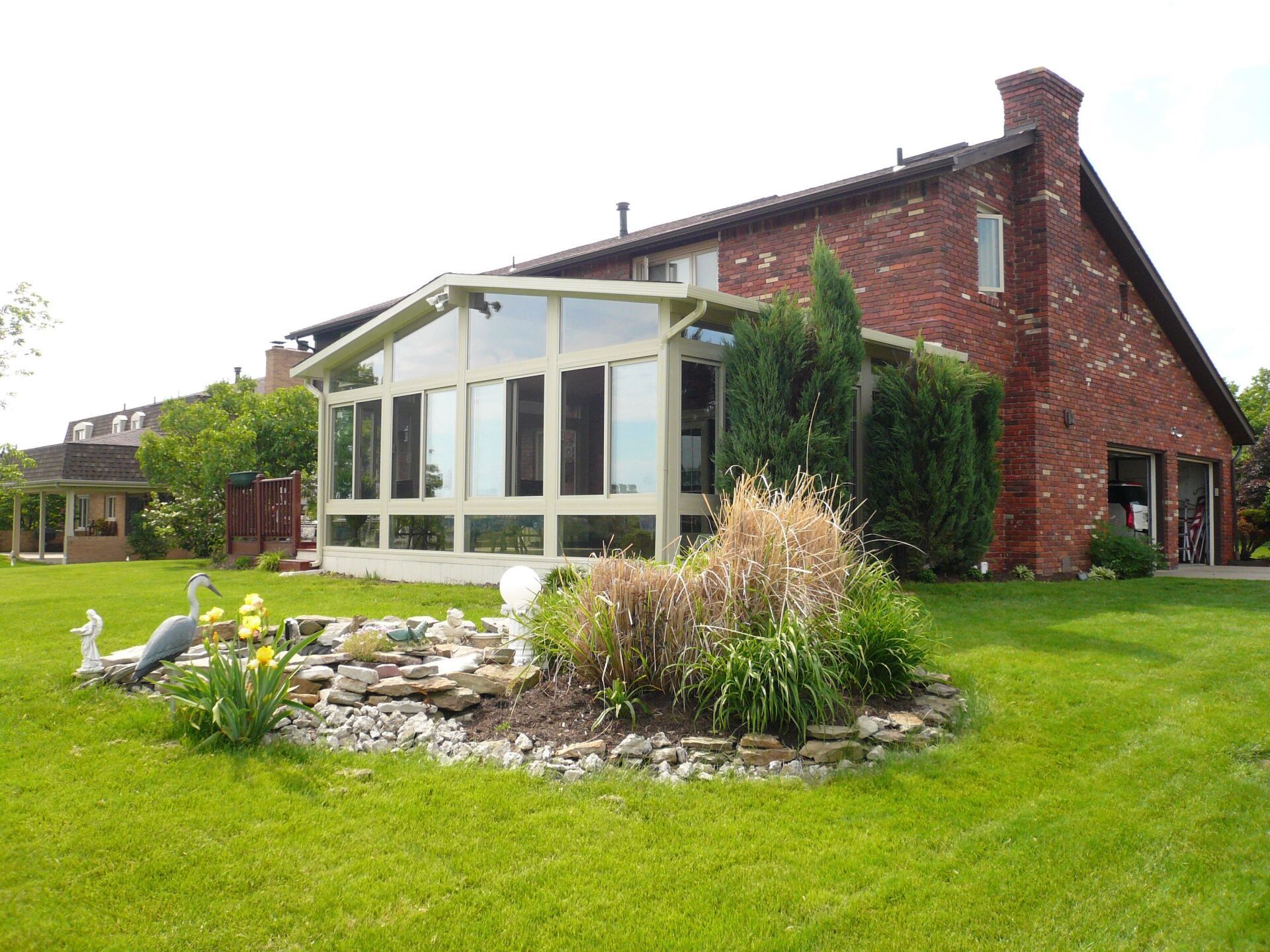 A brick house with a sunroom in the backyard