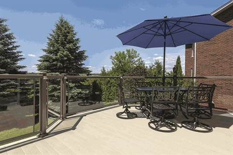 A deck with a table and chairs and an umbrella.