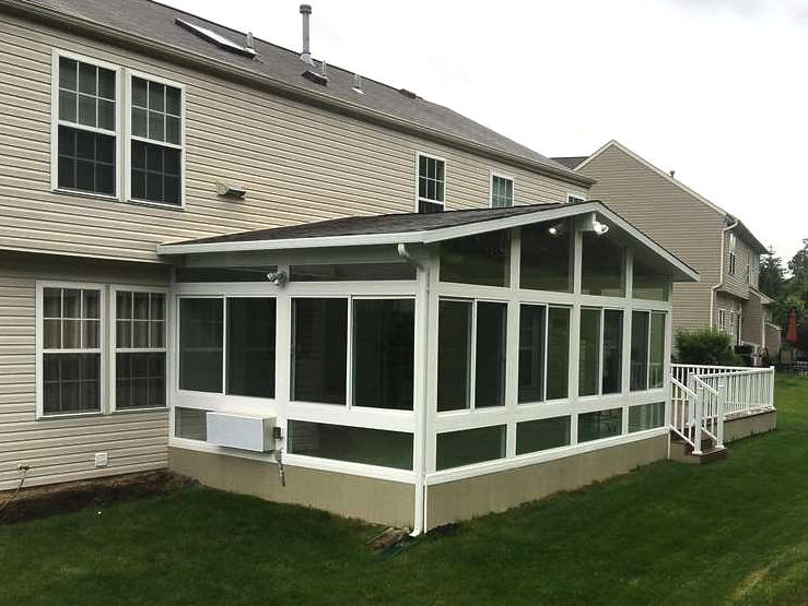 A screened in porch is attached to the back of a house.