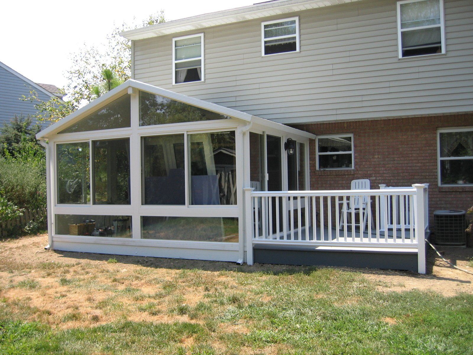 A house with a screened in porch and a white railing