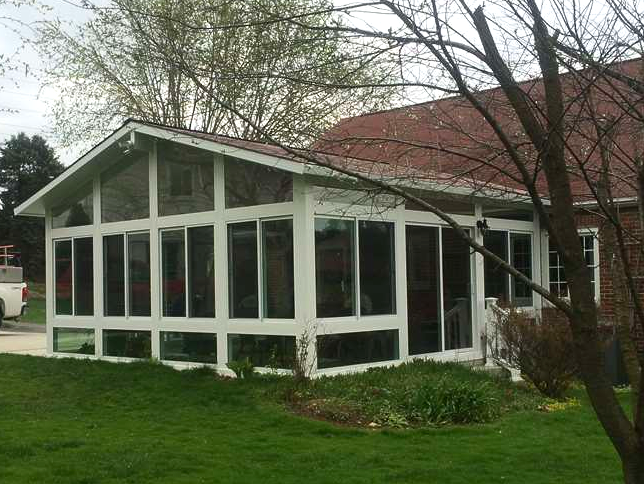 A house with a screened in porch and a lot of windows