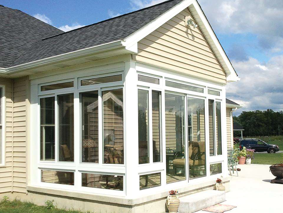 A house with a sunroom with lots of windows
