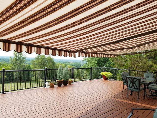 A deck with a table and chairs under an awning