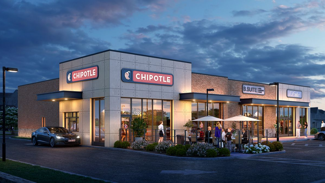 Exterior view of a Chipotle restaurant at dusk with customers dining outside and a car parked in front.