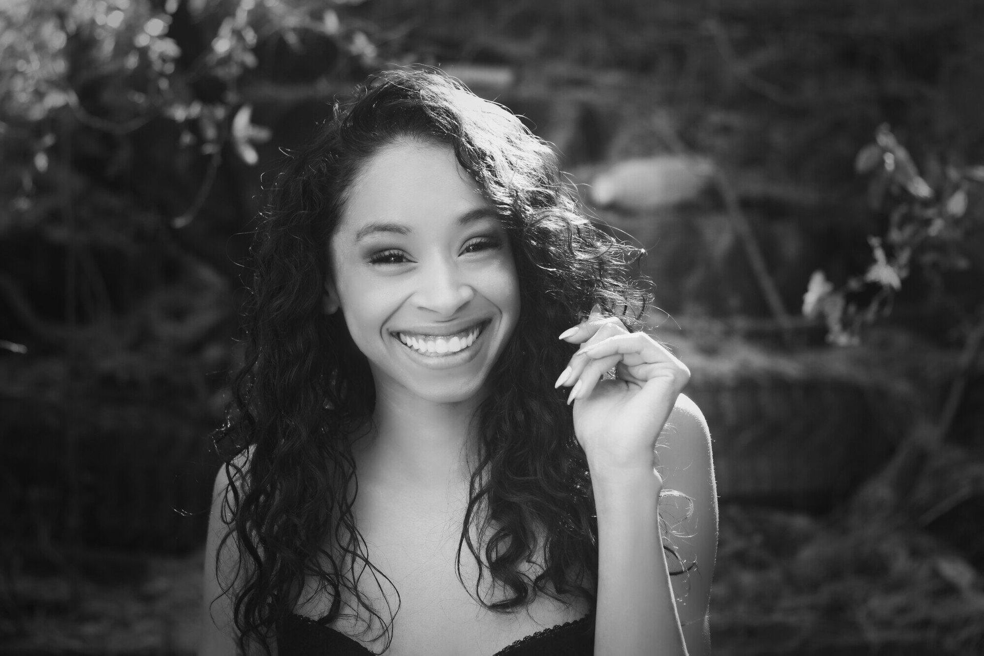 A black and white photo of a woman smiling.