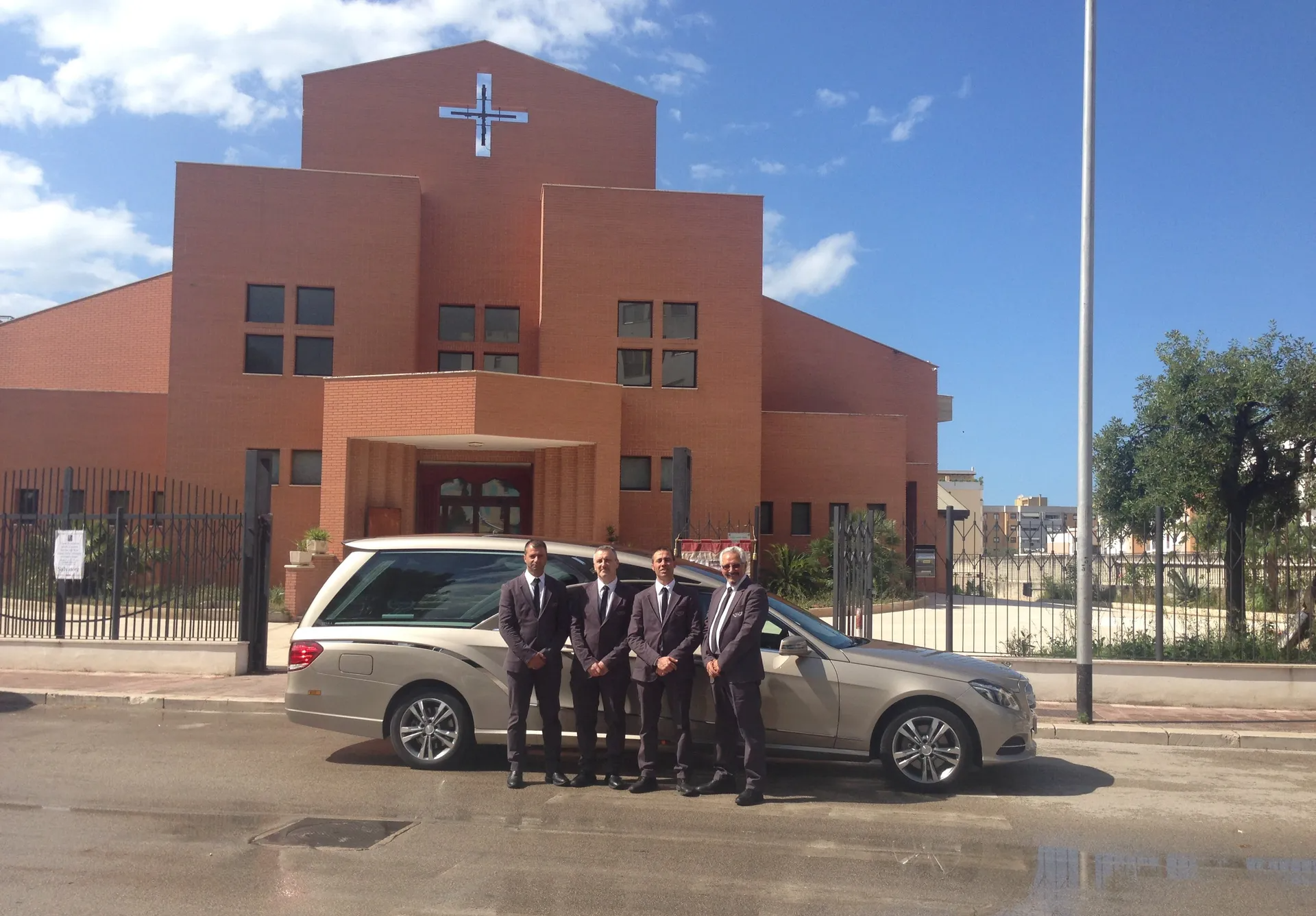 quattro uomini vicino carro funebre