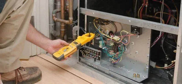 A man is working on an air conditioner with a clamp.
