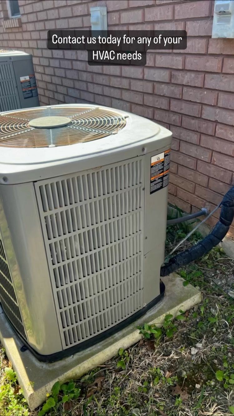 An air conditioner is sitting on the side of a brick building.