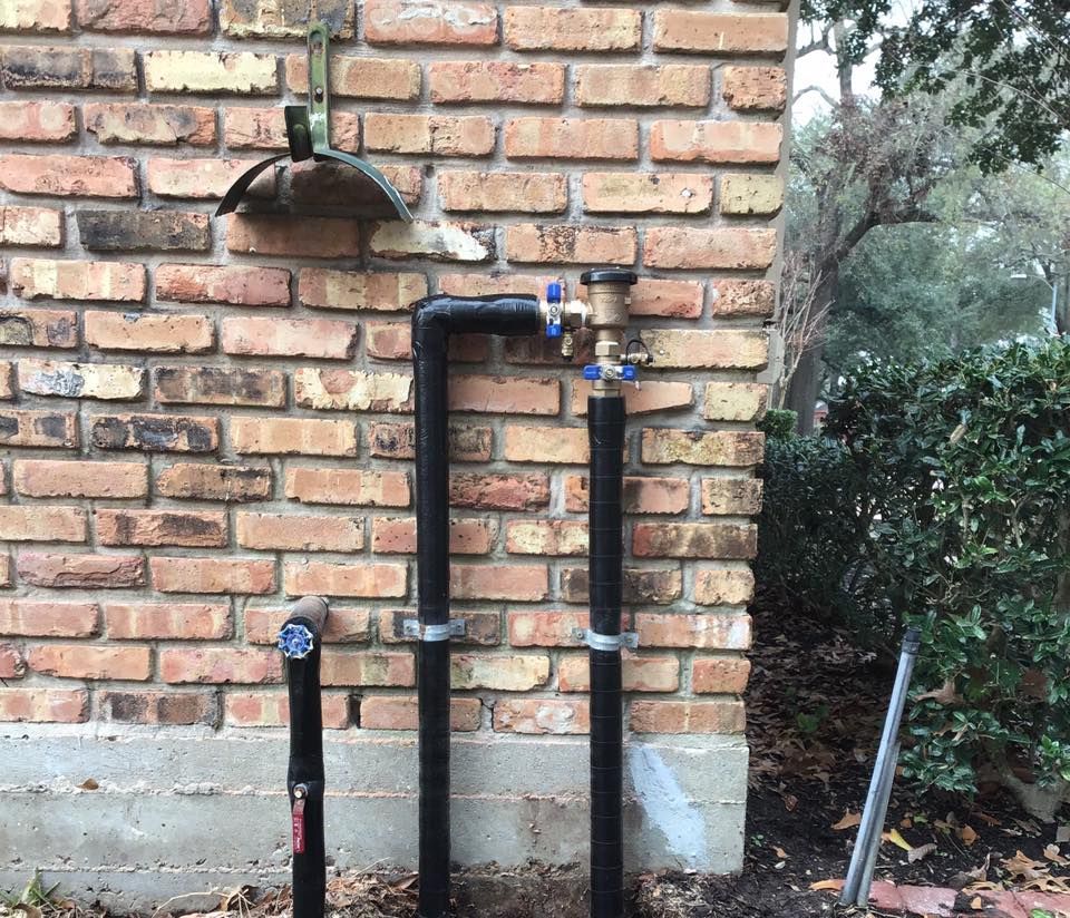 A brick wall with a hose attached to it