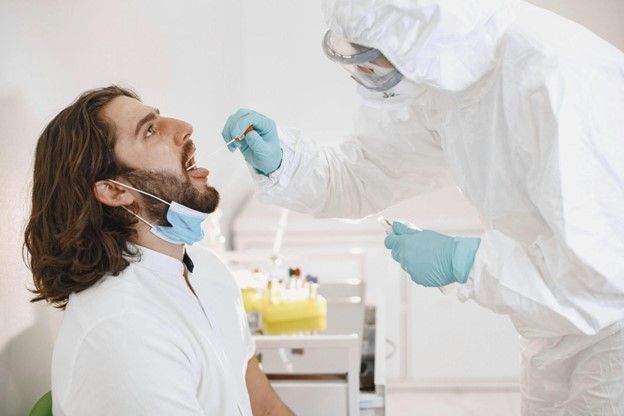 A man is getting a his throat checked.