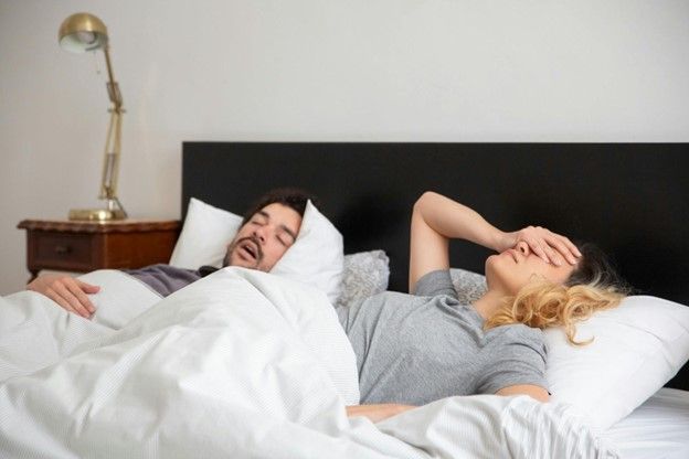 A woman suffering from the loud snoring of her husband. 