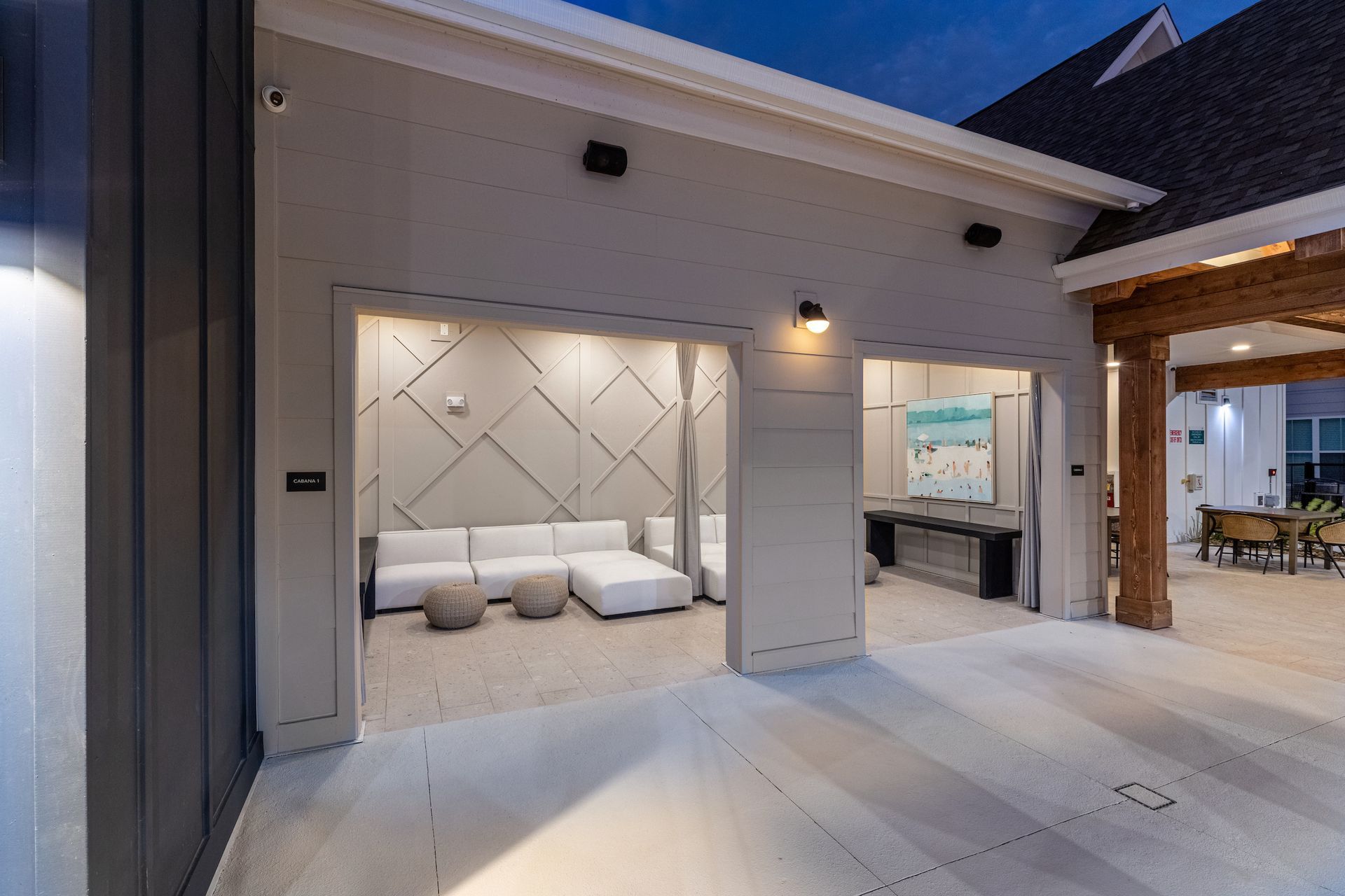 Outdoor lounge area with white couches and modern art.