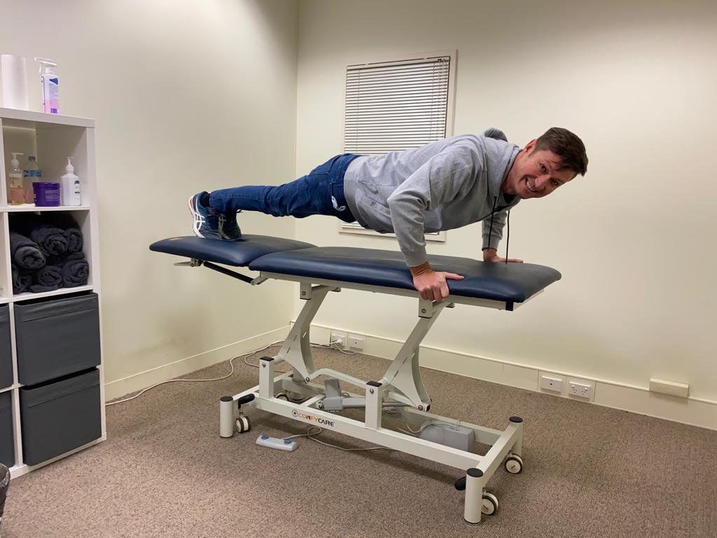 Man doing a pushup on his medical table at work