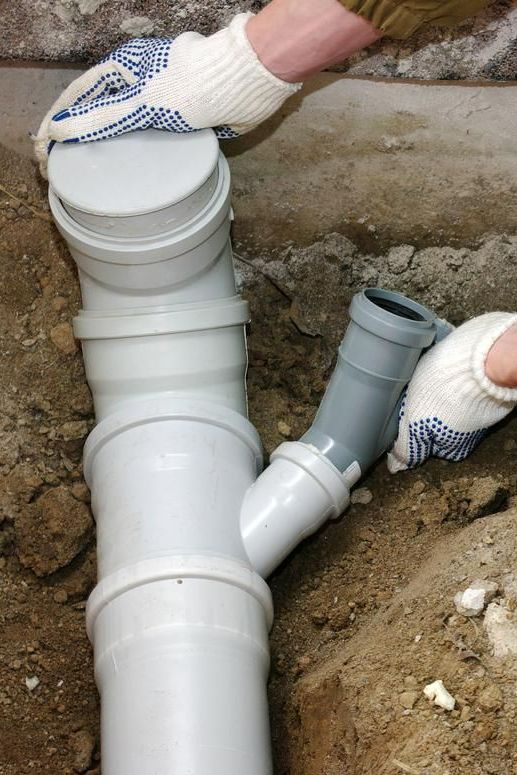 A Person Is Installing a Pipe in The Ground — Howard Hardware and Building Supplies in Howard, QLD