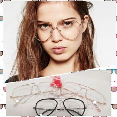 Mujer con gafas redondas extragrandes sobre una vitrina de monturas de gafas