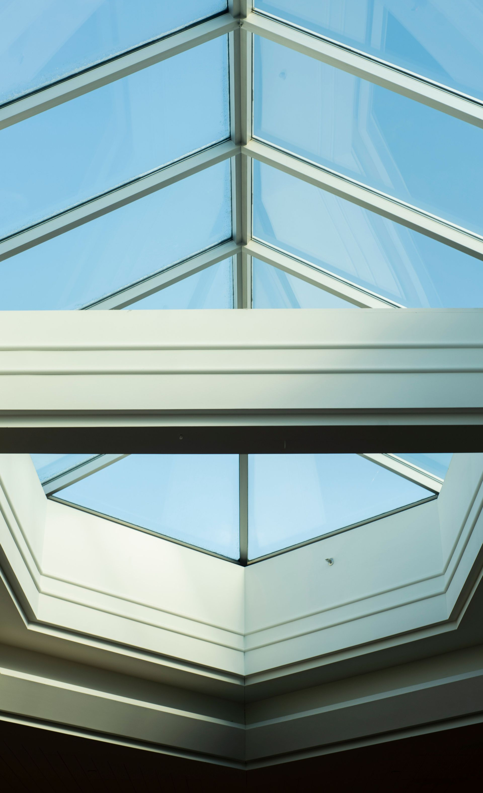 Skylight ceiling with blue glass panels and white framing, viewed from below