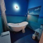 A bathroom with a bathtub and a picture of the ocean on the wall.