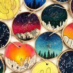 A bunch of wooden slices with different paintings on them.