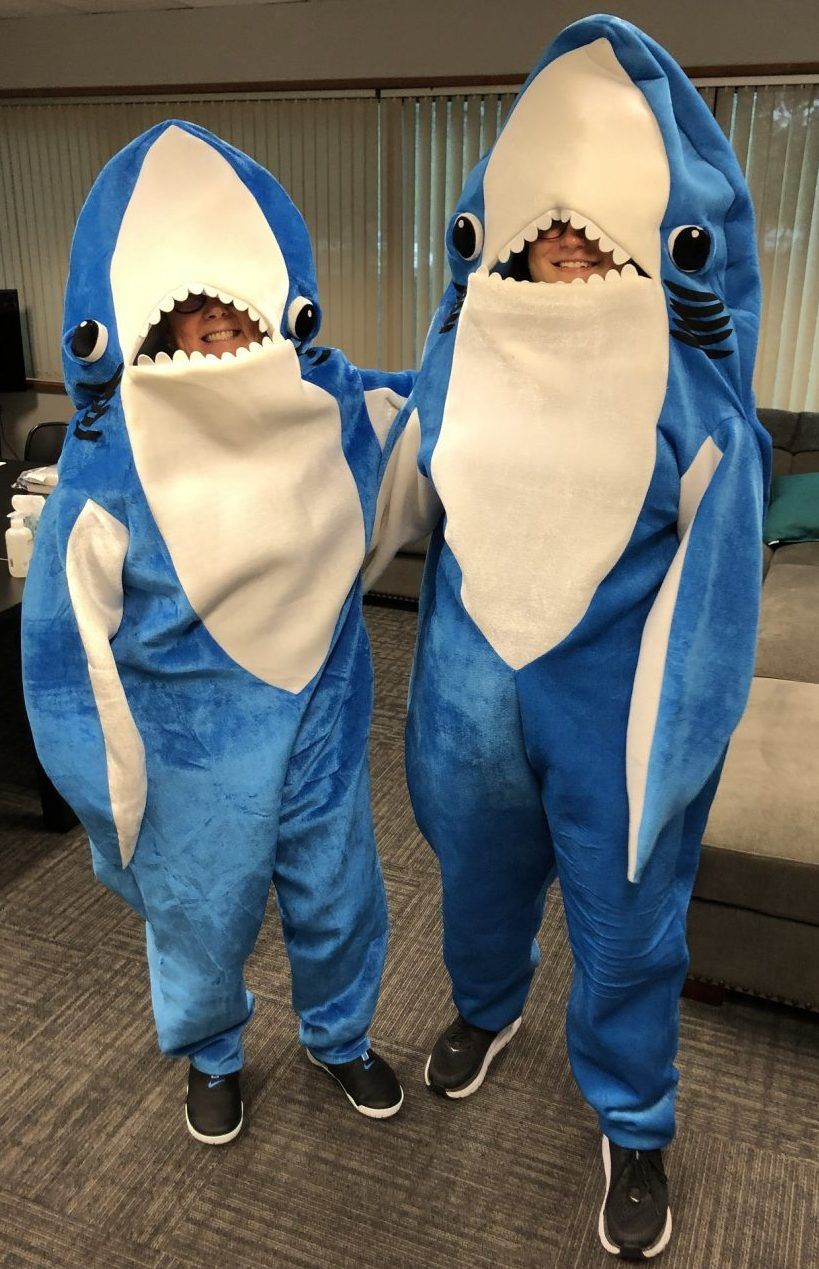 Two people dressed as sharks are standing next to each other.