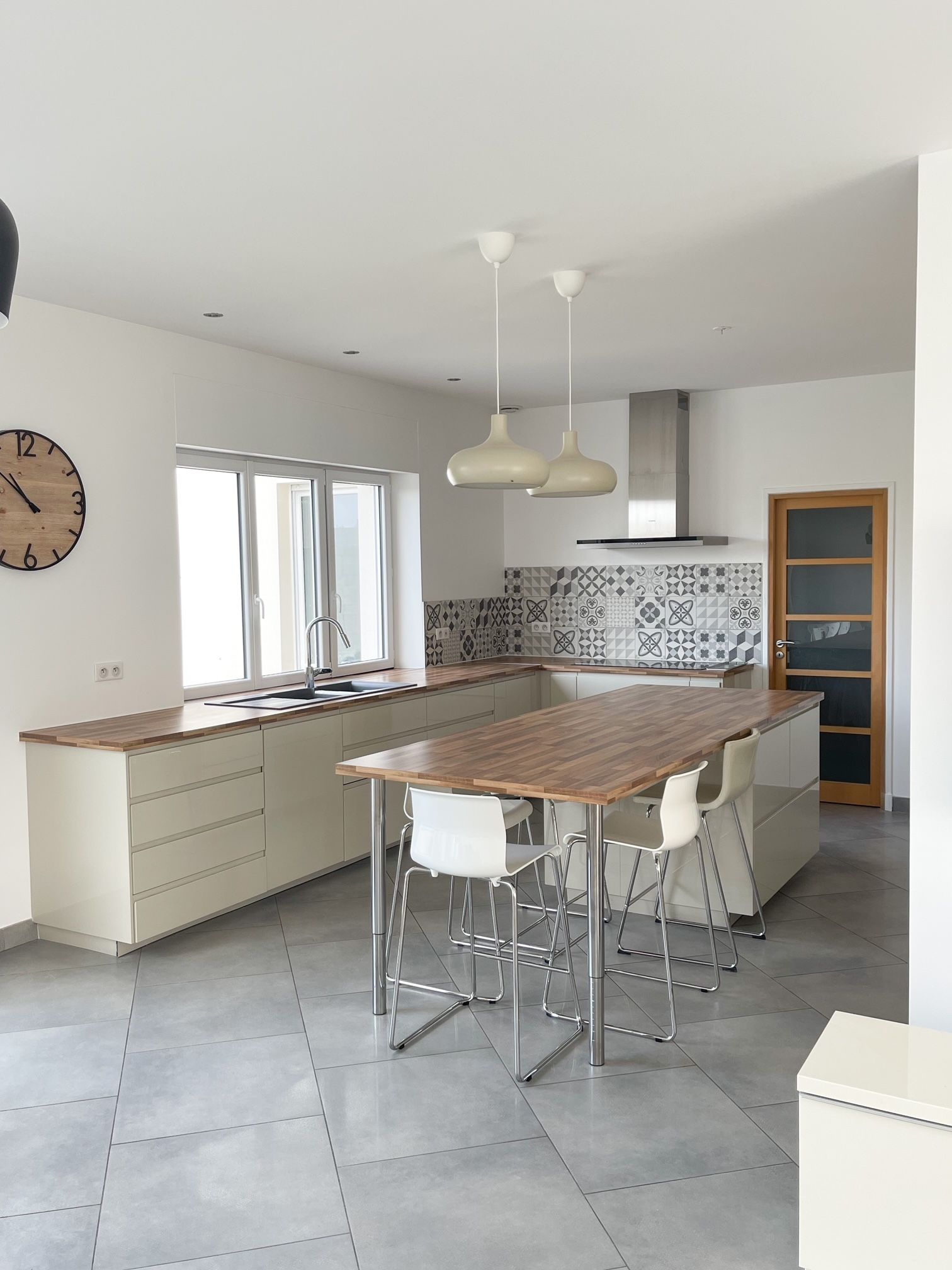 Une cuisine avec une table et des chaises et une horloge sur le mur