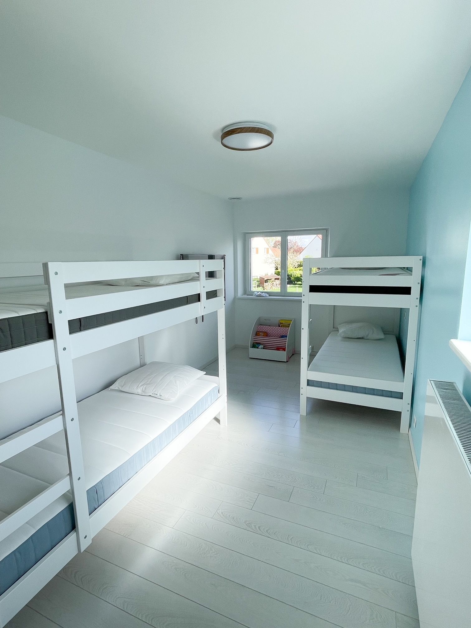 Une chambre avec trois lits superposés et une fenêtre