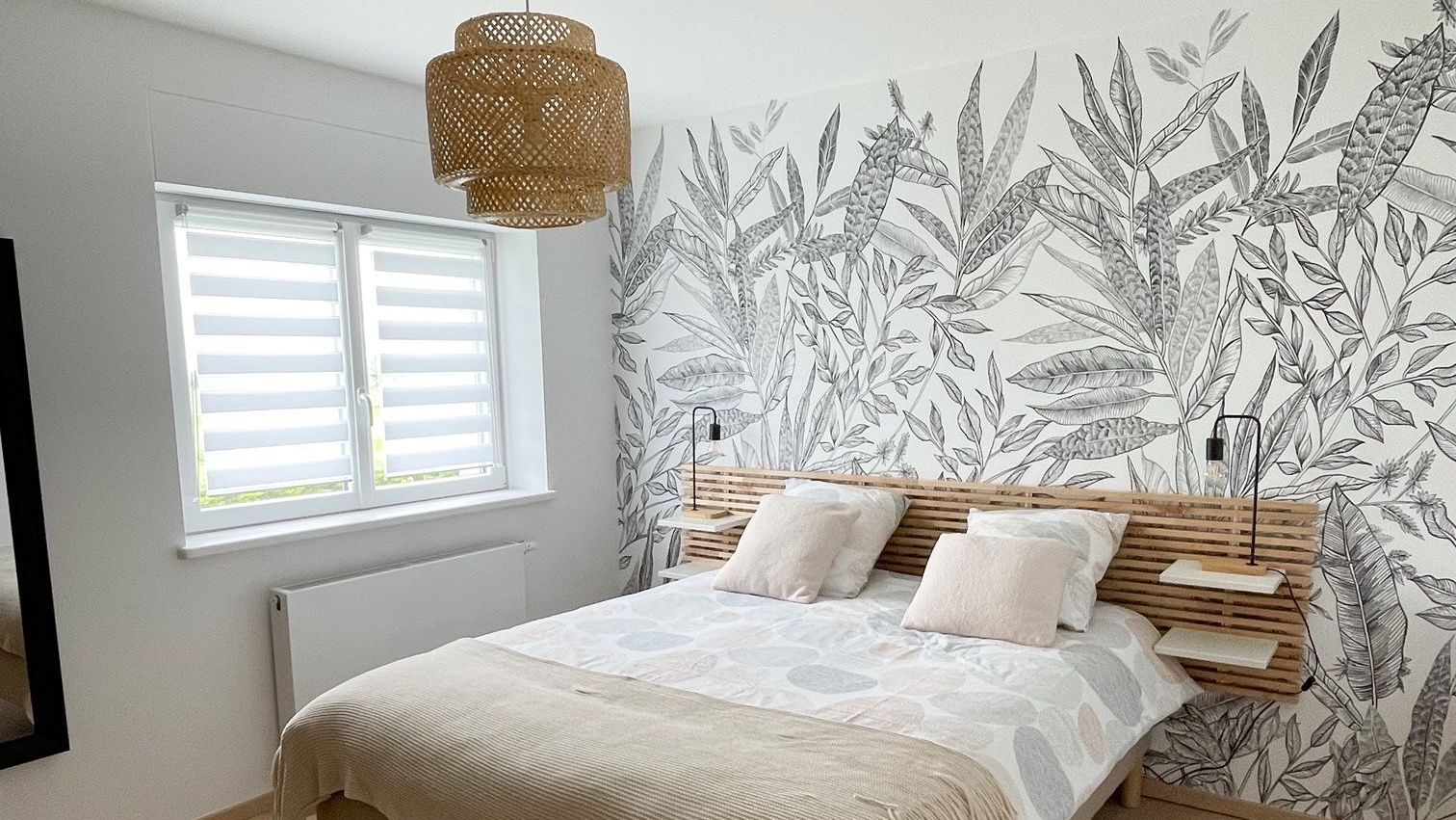 Une chambre avec un lit, une fenêtre et un tableau sur le mur.