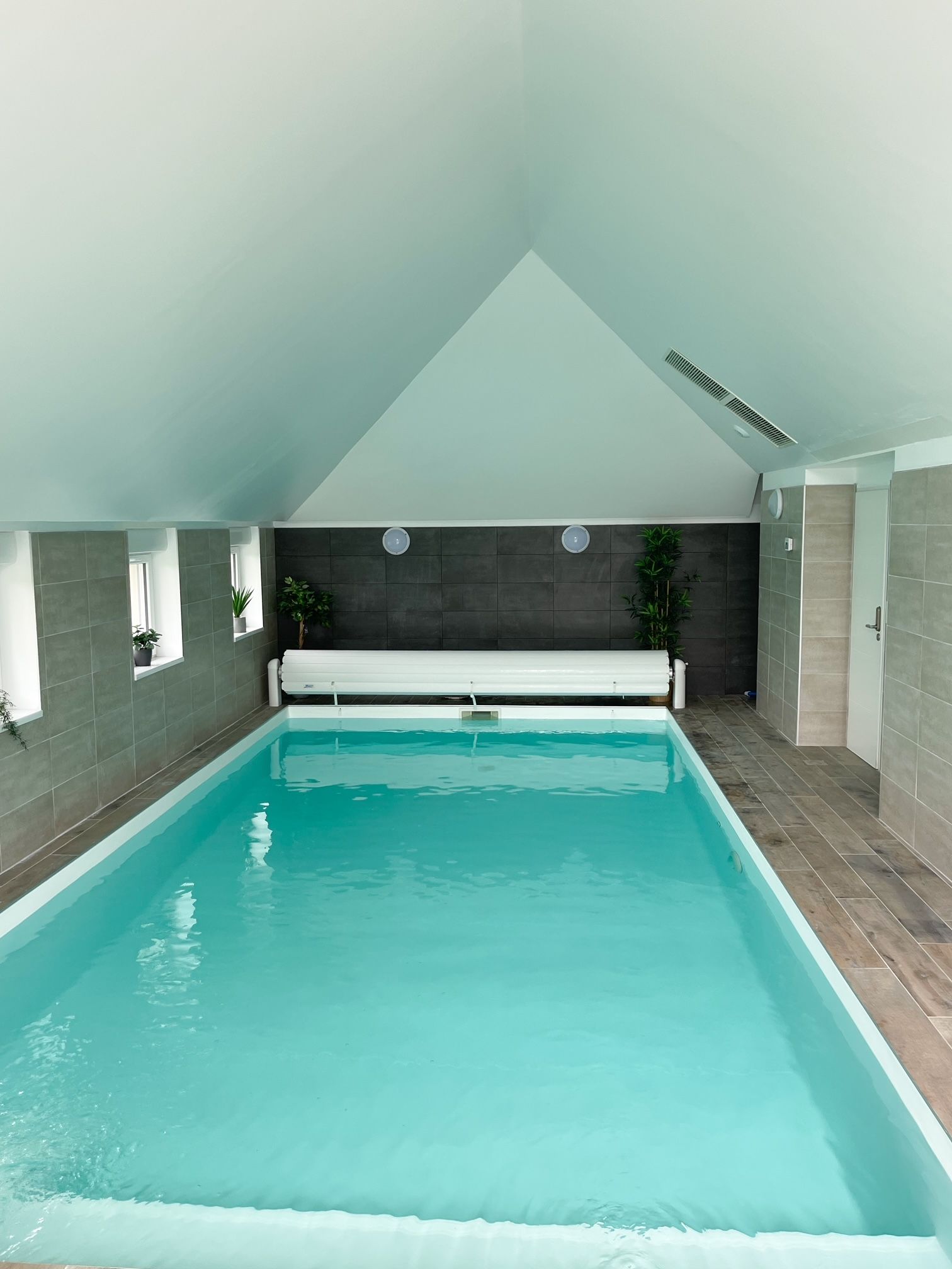 Une grande piscine intérieure avec un plafond voûté