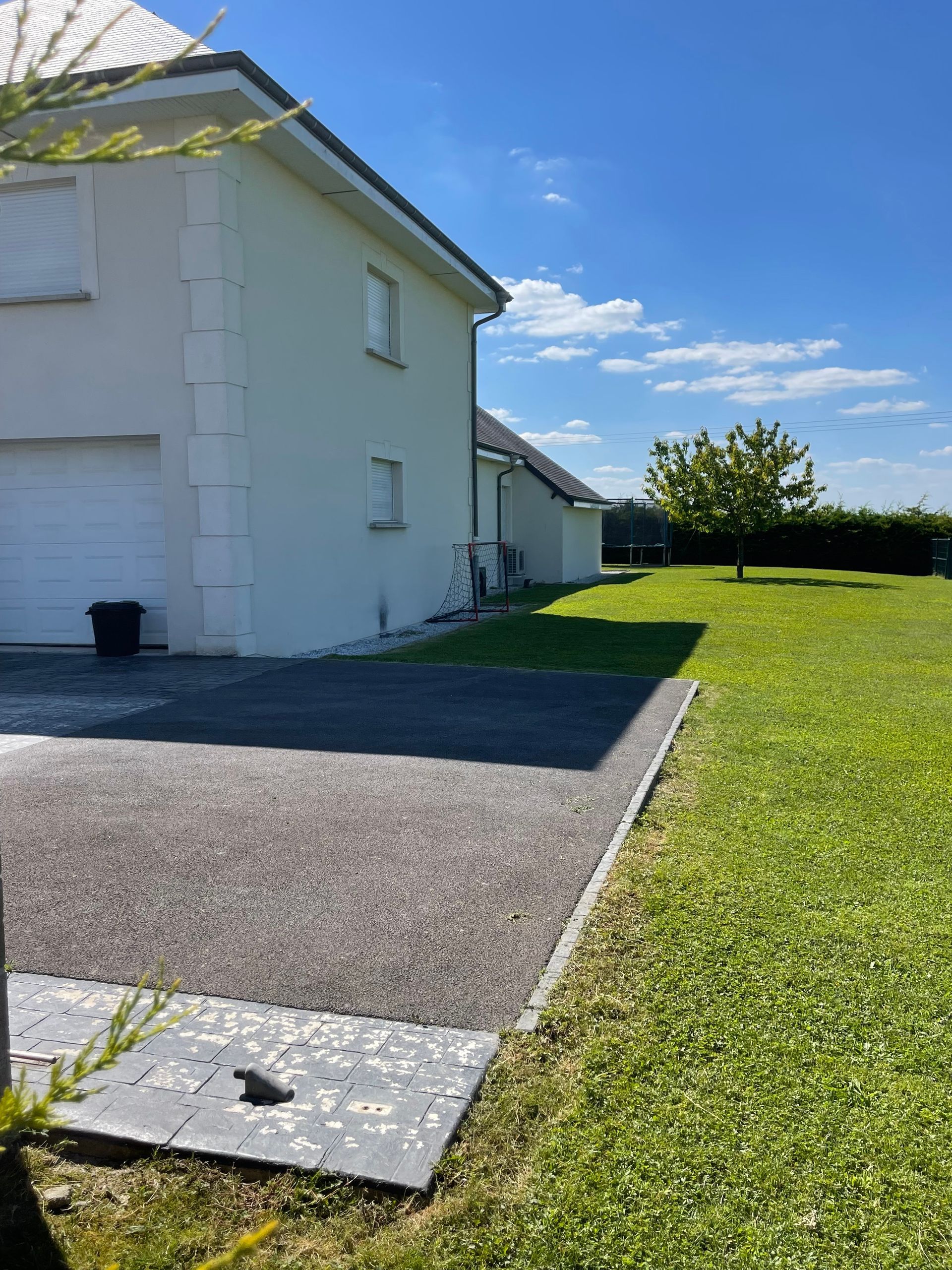 Une maison blanche avec une allée devant elle