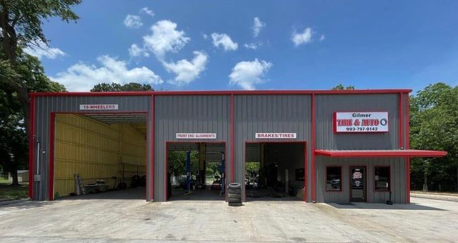 A large gray and red building with a lot of cars parked in front of it.