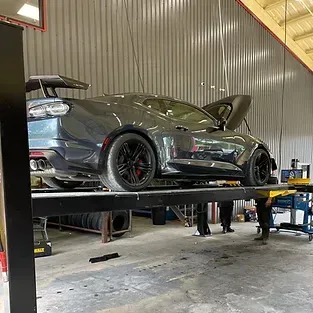 A car is sitting on top of a lift in a garage.