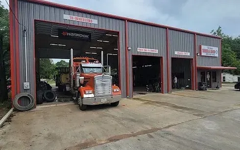 A semi truck is parked in front of a garage.