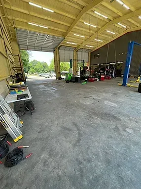 The inside of a garage with a table and ladder.