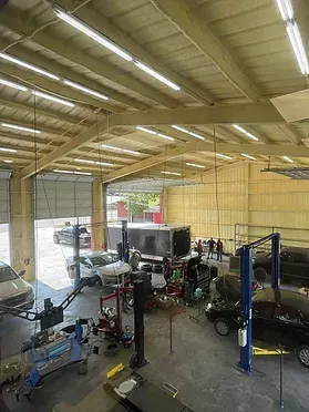 A large garage filled with cars and trucks being worked on.