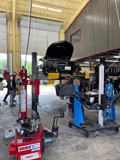 A car is sitting on a lift in a garage.