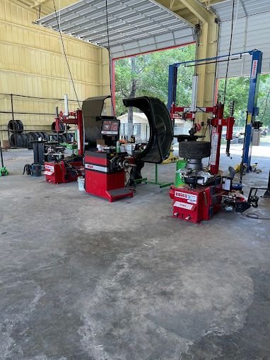 A tire changer is sitting in the middle of a garage.