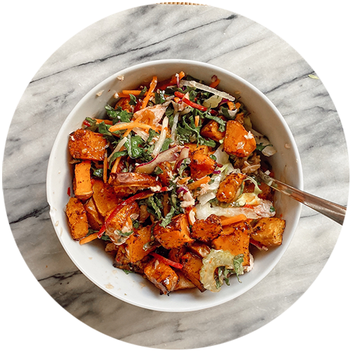 A bowl of food with vegetables and a spoon in it